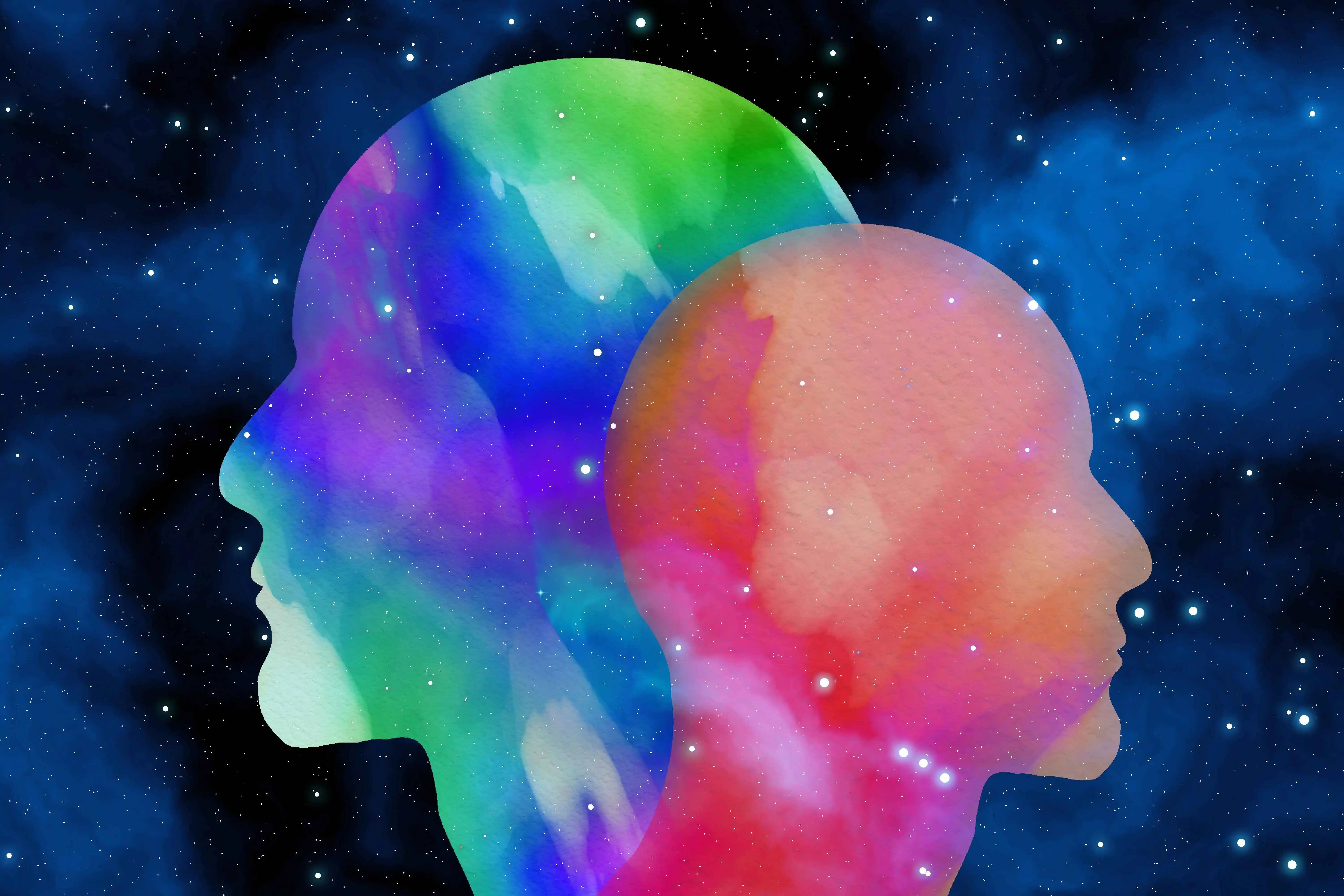 Colorful double human head silhouettes filled with galaxy patterns, featuring vibrant watercolor textures in green, blue, purple, and red against a starry night sky background, symbolizing psychology, duality, and cosmic consciousness.